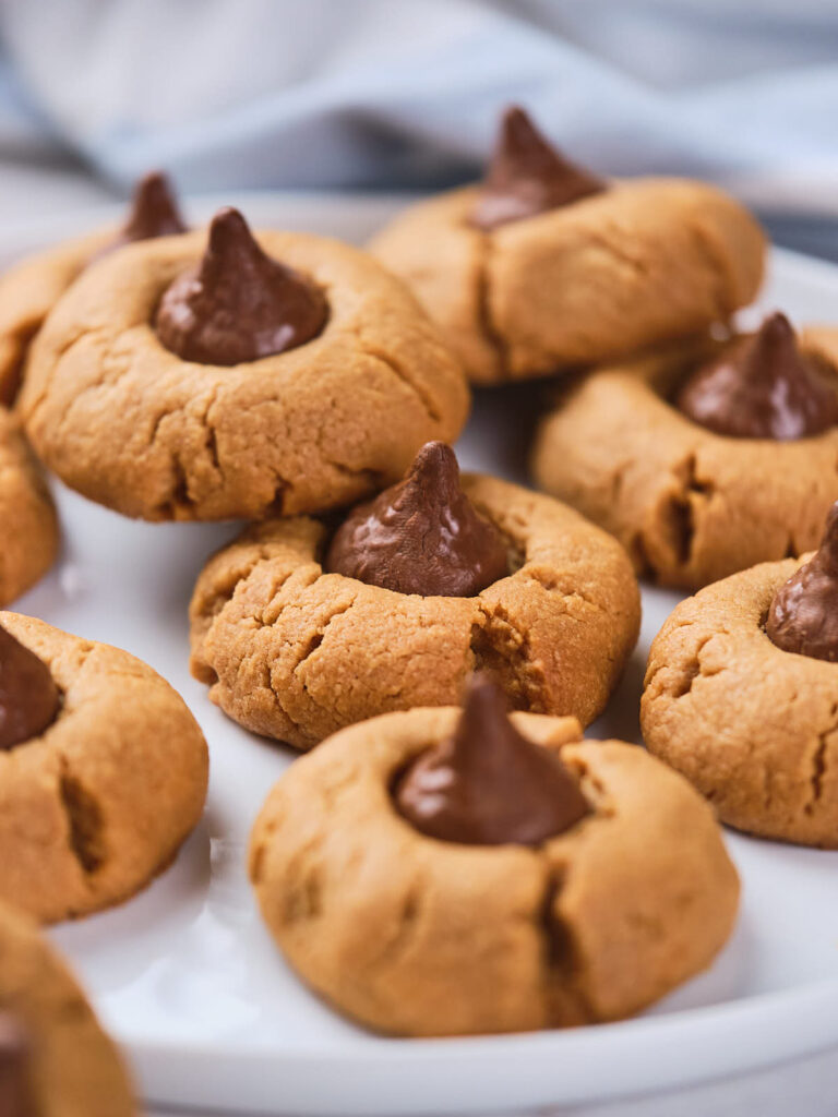 A plate of peanut butter blossom cookies with chocolate centers.