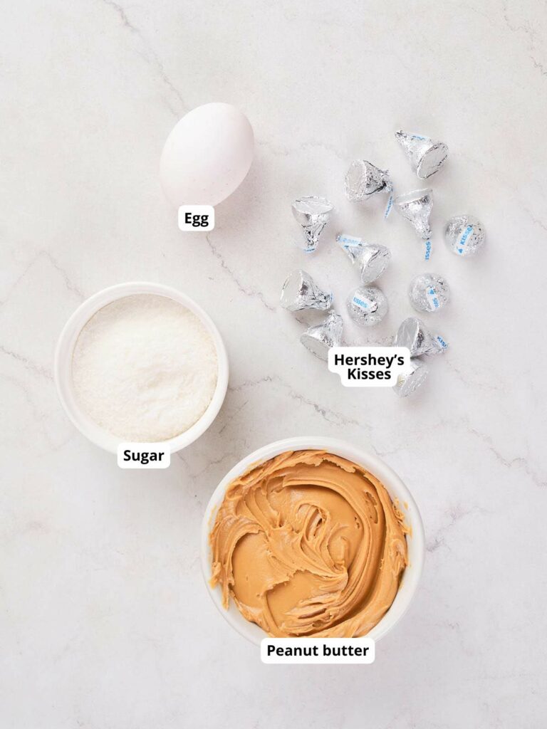 Ingredients for peanut butter blossoms on a marble surface.