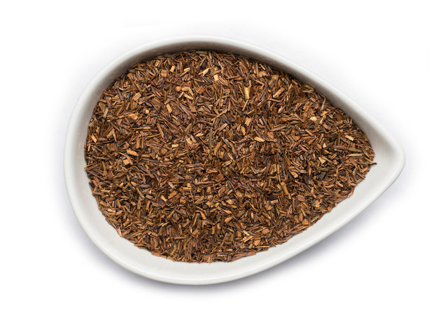 A white ceramic dish containing loose rooibos tea leaves.