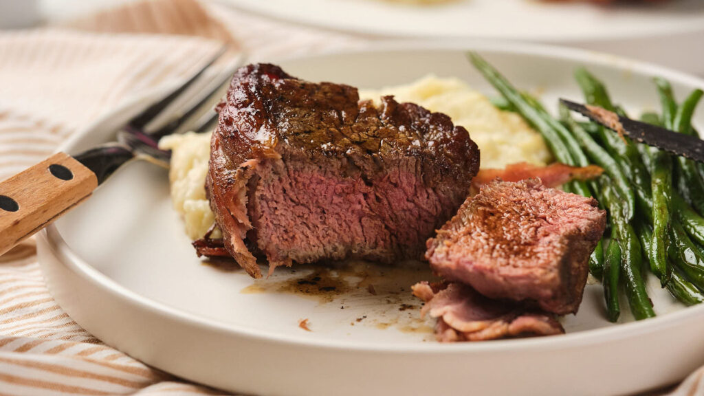 A plate of bacon wrapped fillet mignon.