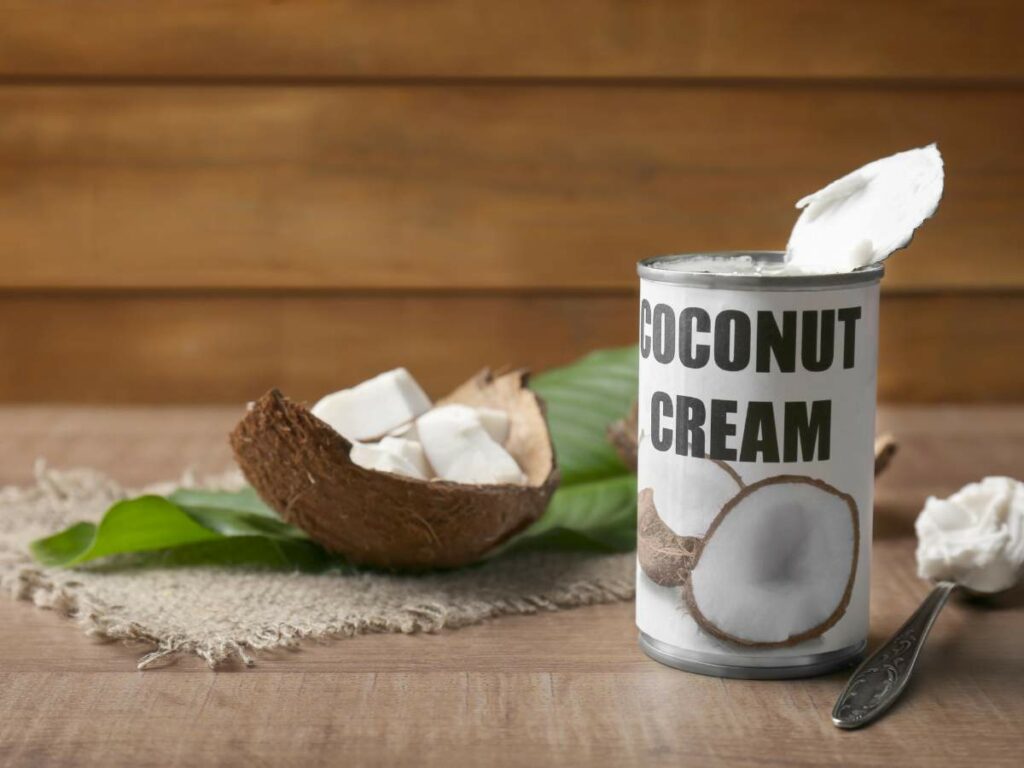 A can of coconut cream with a spoonful of cream on top.