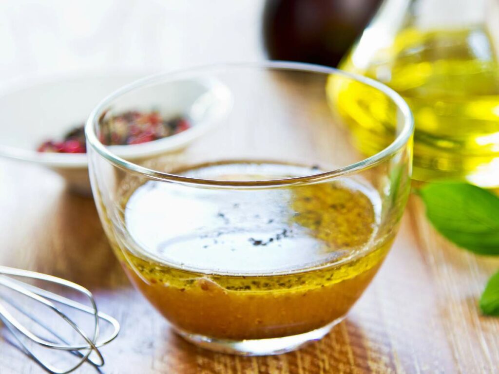 A clear glass bowl filled with vinaigrette.