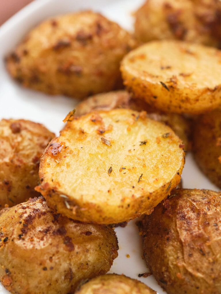 Close-up of parmesan potato slices on a white plate.