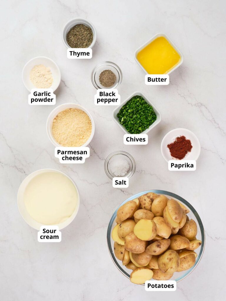 Ingredients for parmesan potatoes arranged on a white surface.