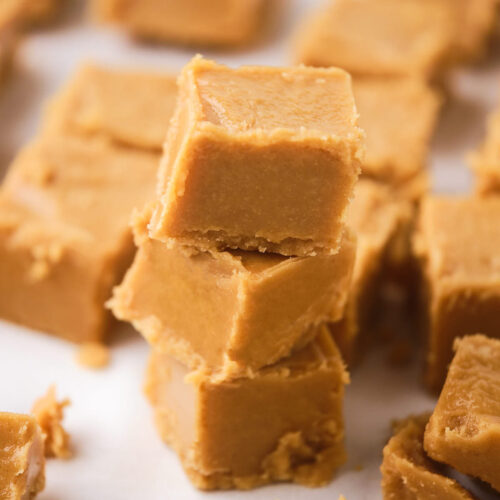 A stack of three smooth peanut butter fudge on a white surface.