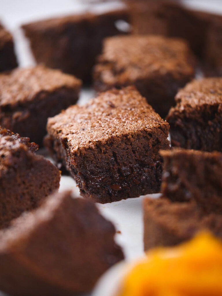 Close-up of several pumpkin brownies arranged on a surface, showcasing their moist, fudgy texture.