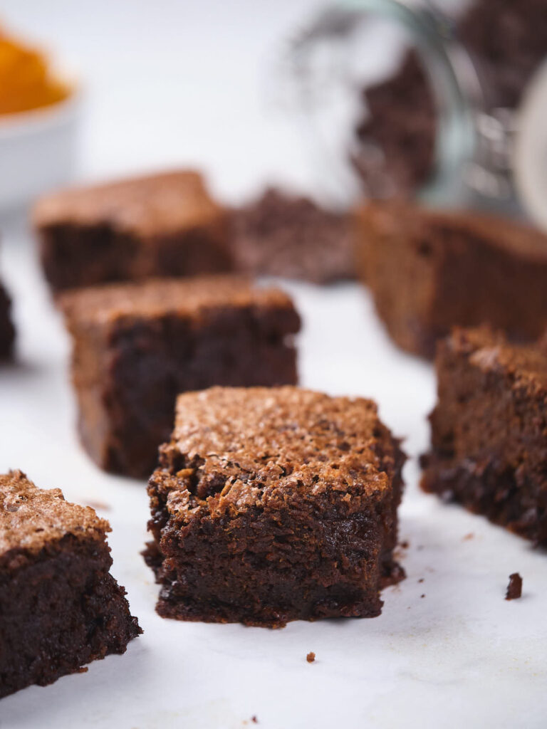 Close-up of several pumpkin brownies on a white surface.