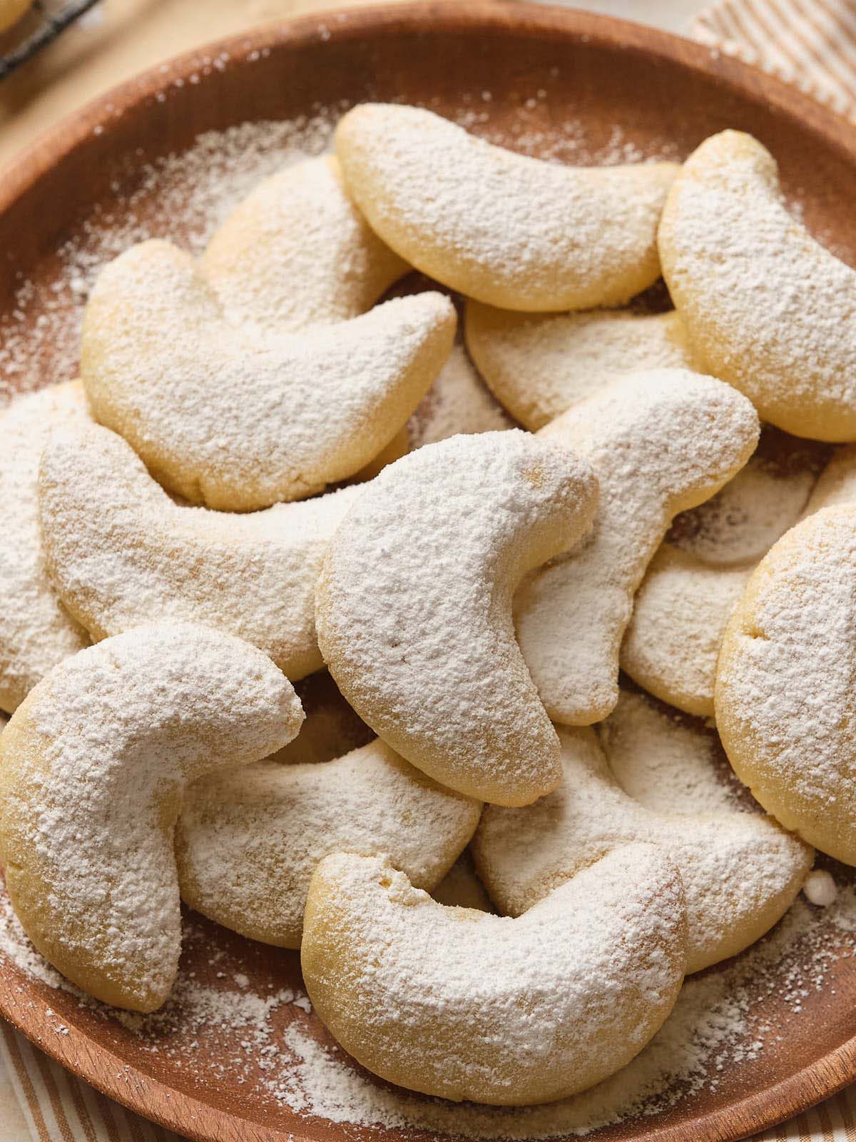 A plate of almond crescent cookies dusted with powdered sugar.