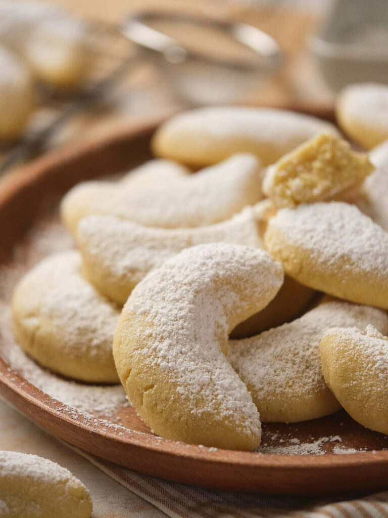 A plate of crescent-shaped cookies dusted with powdered sugar.