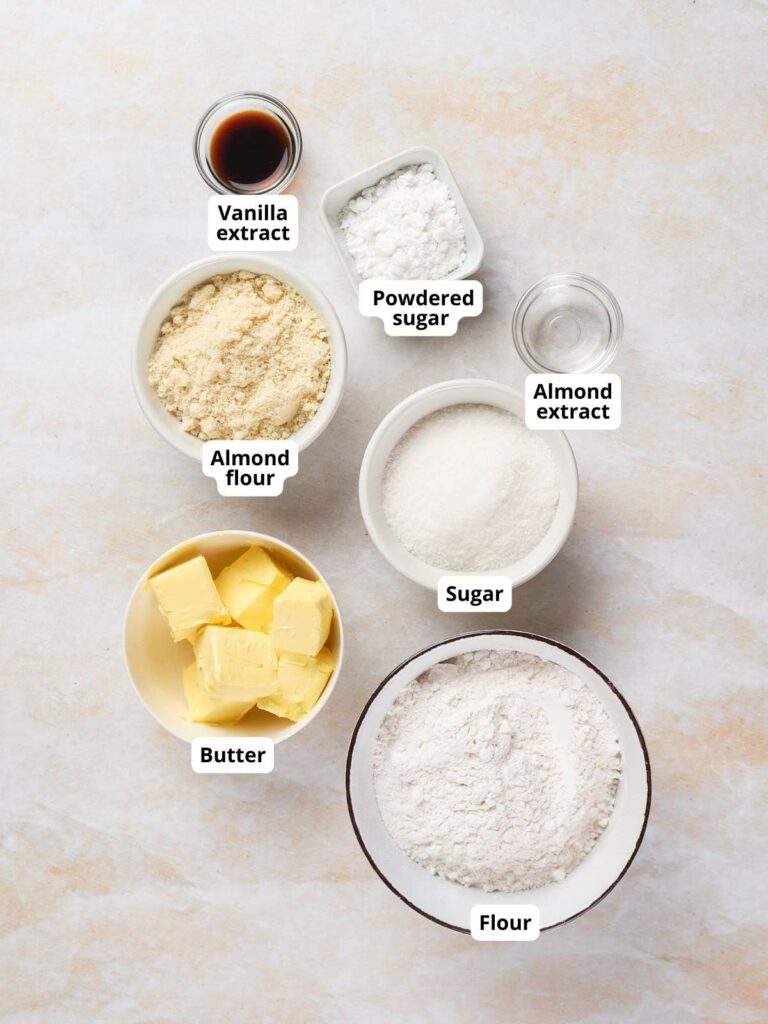 Ingredients for almond crescent cookies arranged on a light surface.