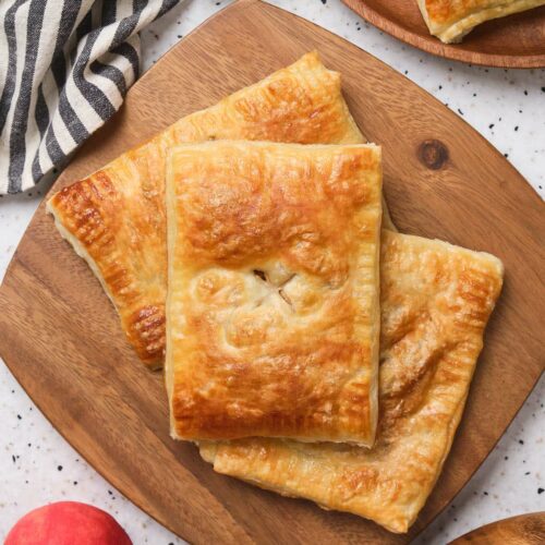 Pieces of apple pie laid out on a wooden board.