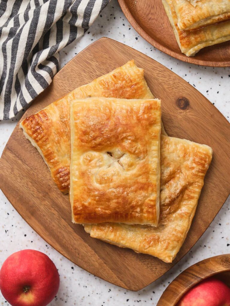 Pieces of apple pie laid out on a wooden board.