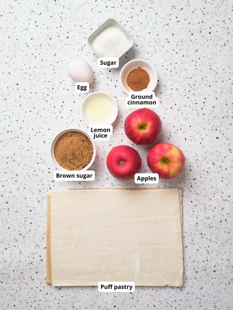 Ingredients for apple pie laid out on a white surface, each labeled.