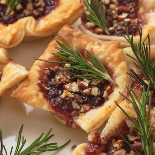 Close-up of brie bites topped garnished with sprigs of rosemary.