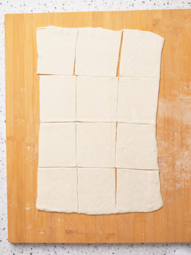 Rectangular sheet of dough, rolled out and cut into 12 even squares.