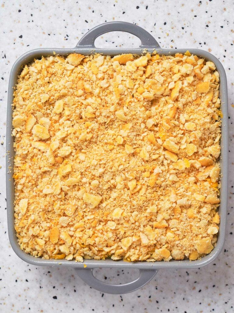 A square baking dish filled with a crumbly, golden crust on top of a casserole.