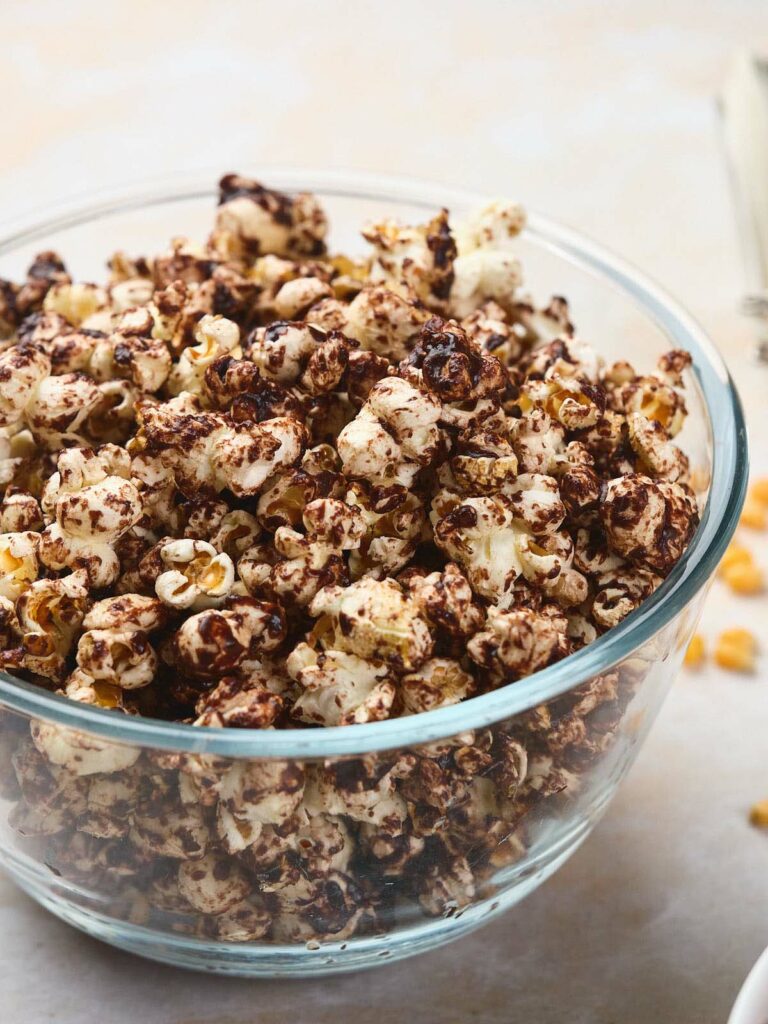 A clear glass bowl filled with chocolate popcorn.