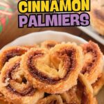 Close-up of cinnamon palmiers stacked on a plate, with a colorful napkin in the background.