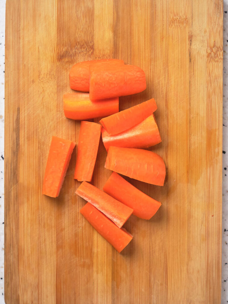 Chopped carrots on a wooden cutting board.