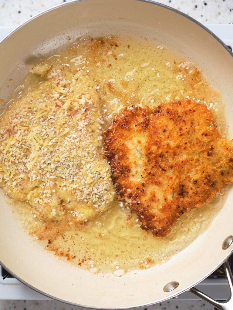 Chicken being fried in a skillet.