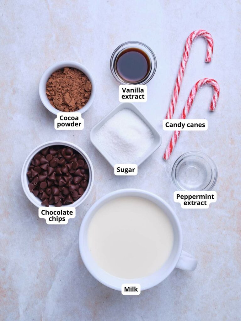 Ingredients for making peppermint hot chocolate are arranged on a surface.