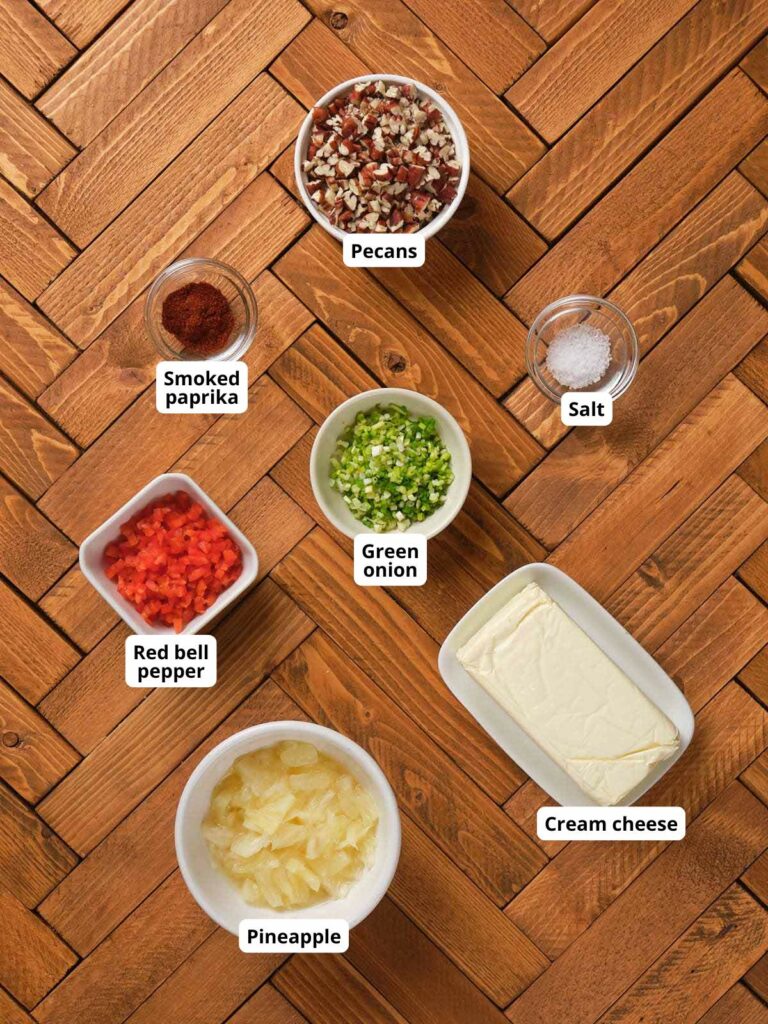 Ingredients for pineapple cheese ball on a wooden surface include pecans.