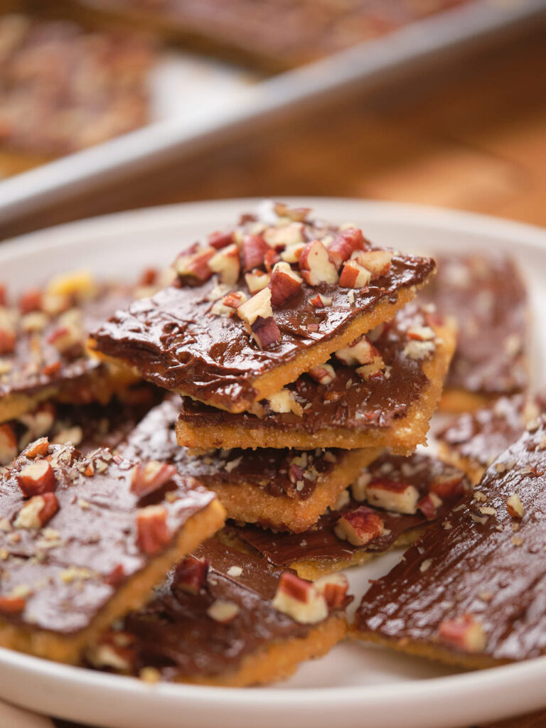 A plate of saltine toffee topped with chopped nuts.