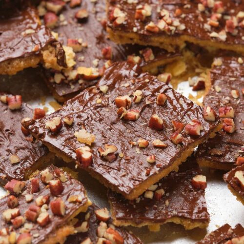 Close-up of saltine toffee squares topped with chopped pecans.