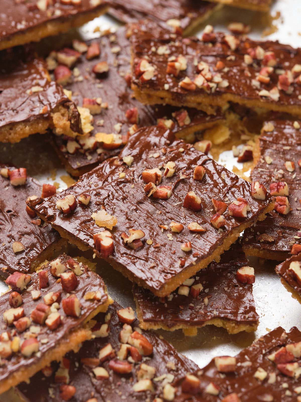 Close-up of saltine toffee squares topped with chopped pecans.