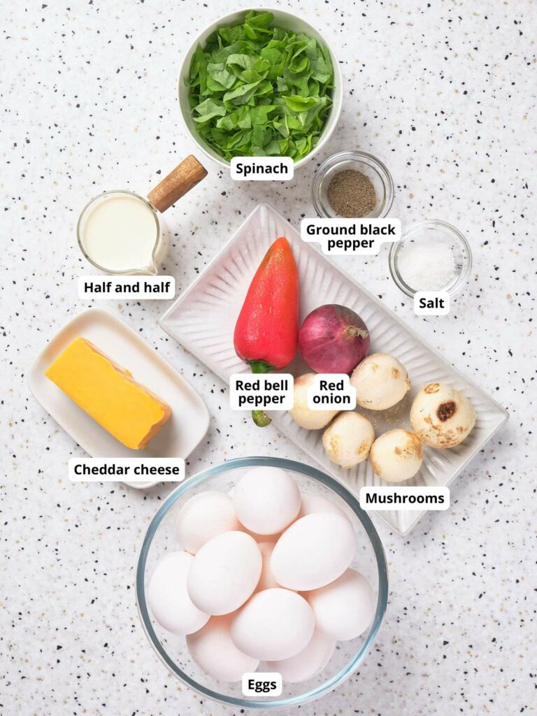 Ingredients for sheet pan eggs laid out on a speckled counter.