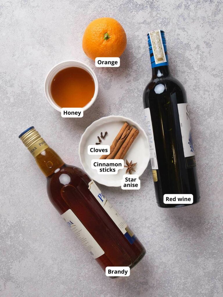 An assortment of mulled wine ingredients, arranged on a textured surface.