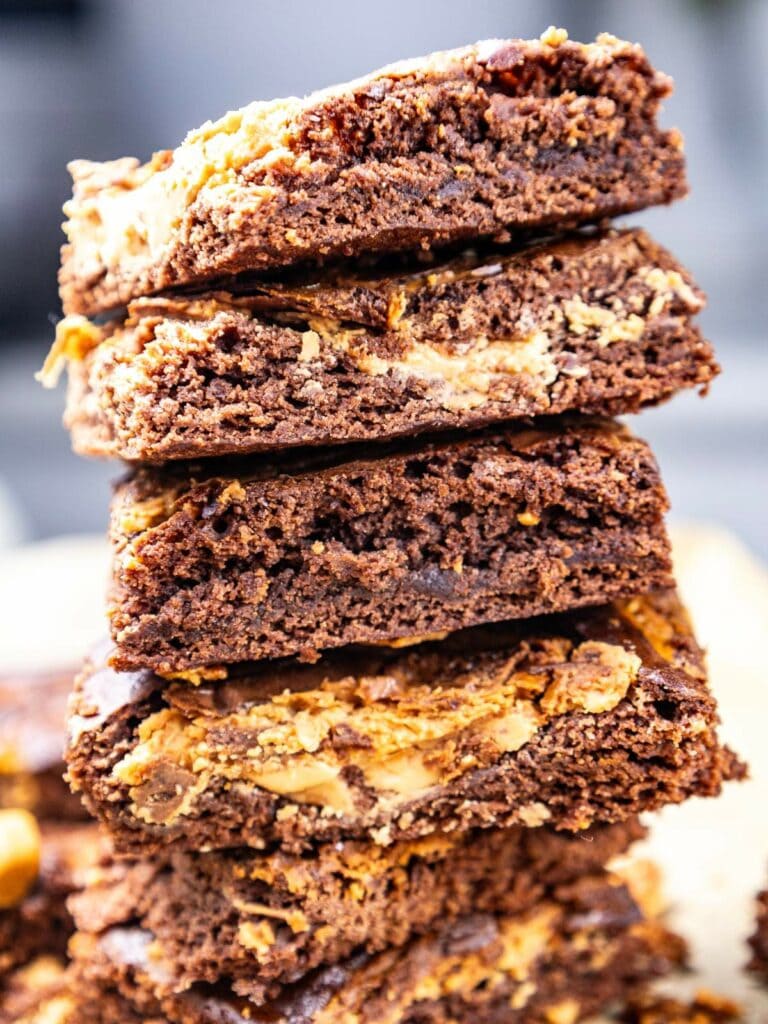 A stack of brownies with a fudge and peanut butter swirl, showing a dense and rich texture.