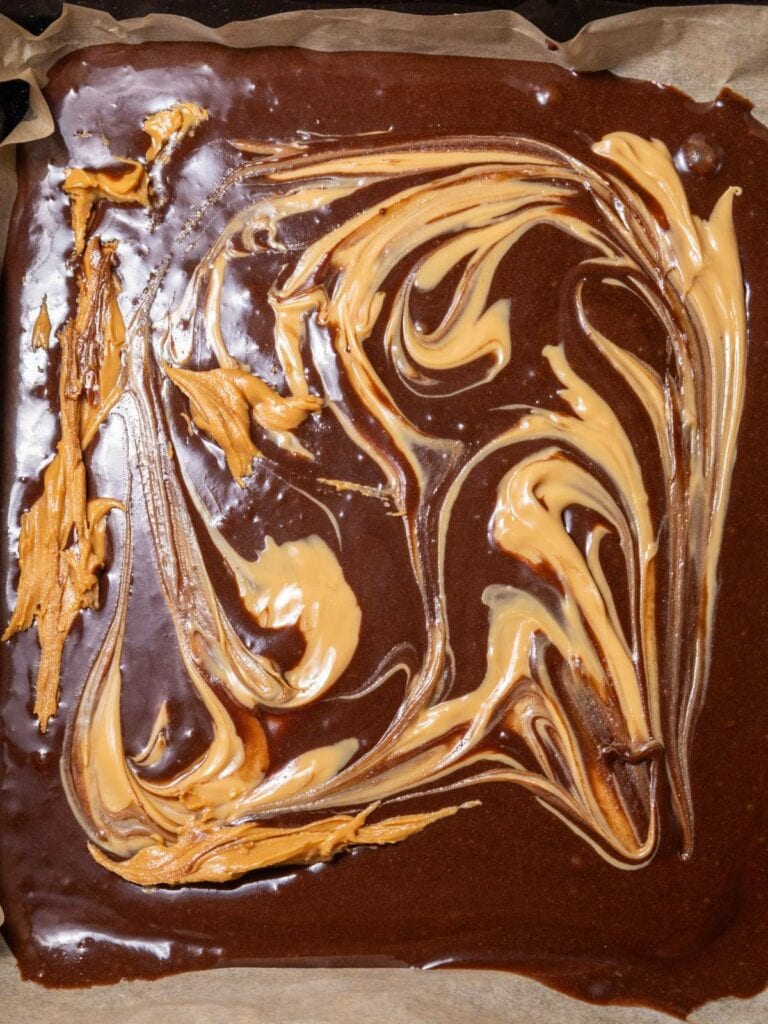 Brownie batter swirled with peanut butter in a baking pan.