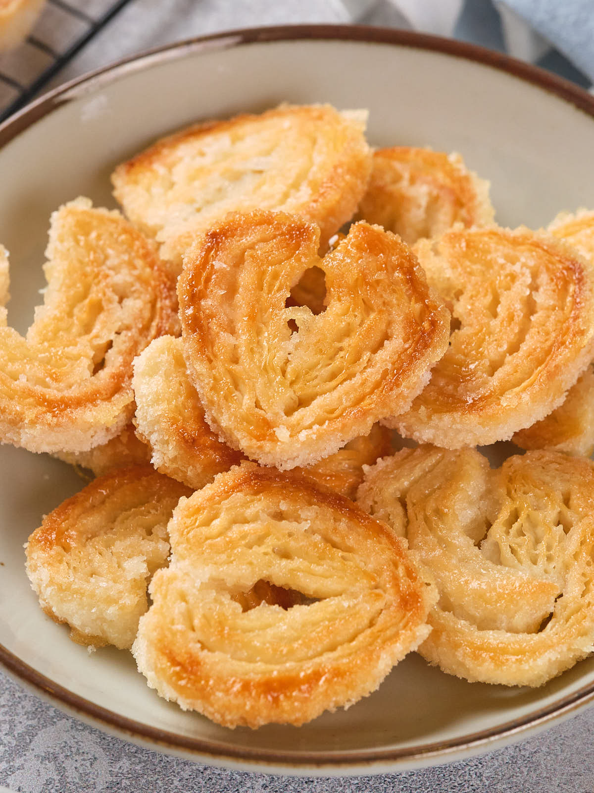 A bowl of sugar-coated palmier cookies, arranged neatly.