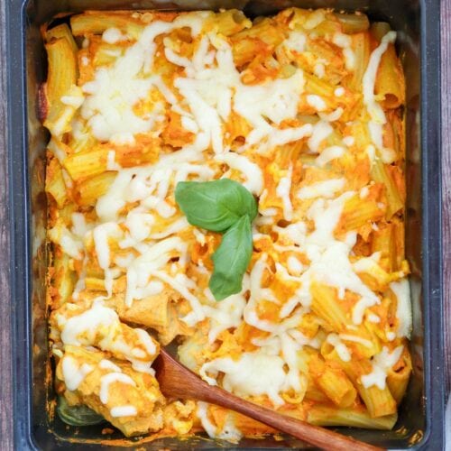 Pumpkin pasta with melted cheese and tomato sauce in a rectangular dish.