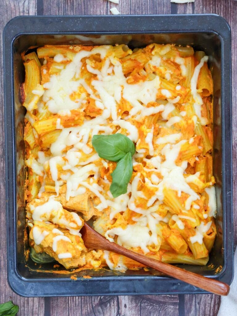 Pumpkin pasta with melted cheese and tomato sauce in a rectangular dish.