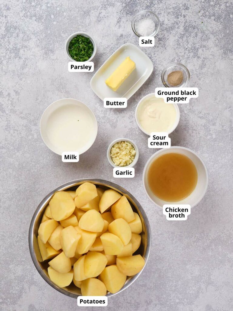 Ingredients for mashed potatoes displayed on a light colored surface.