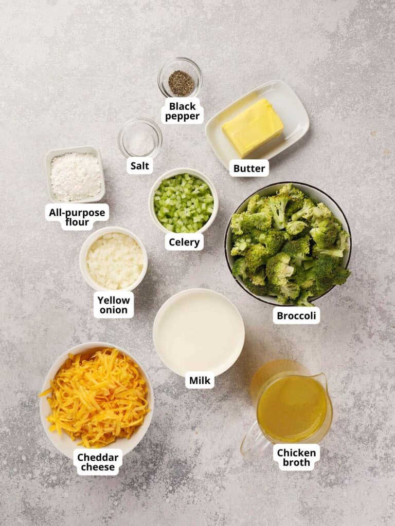 Ingredients for broccoli cheddar soup are neatly arranged on a light colored surface.