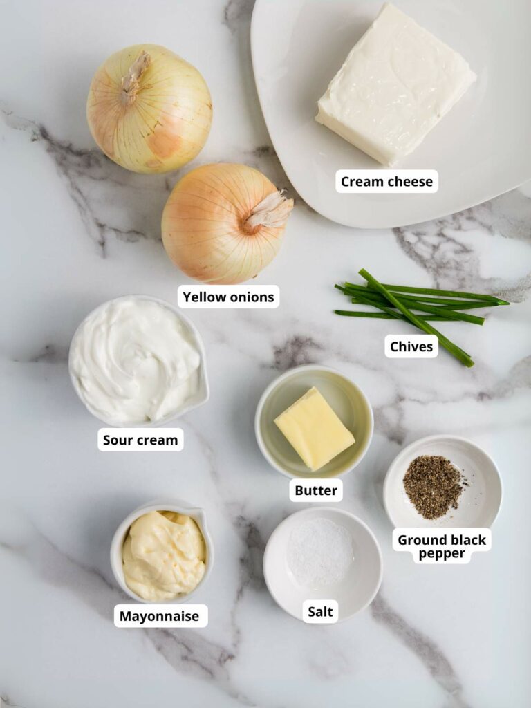 Ingredients for french onion dip on a marble surface.