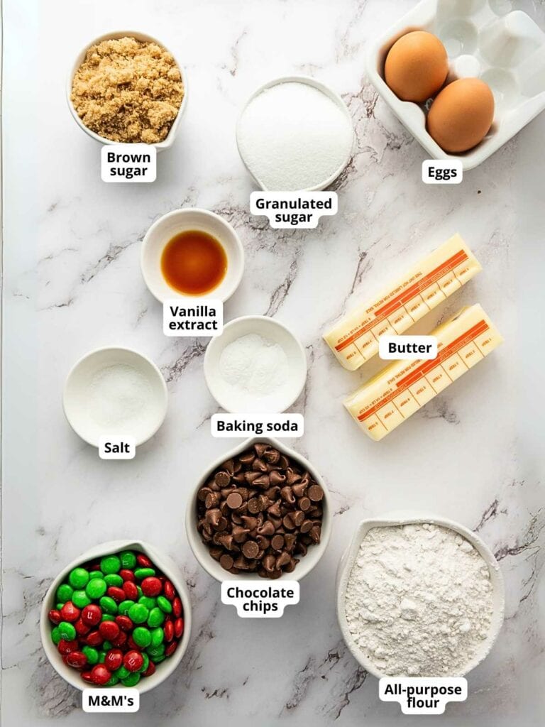 Ingredients for m&m cookies arranged on a marble surface