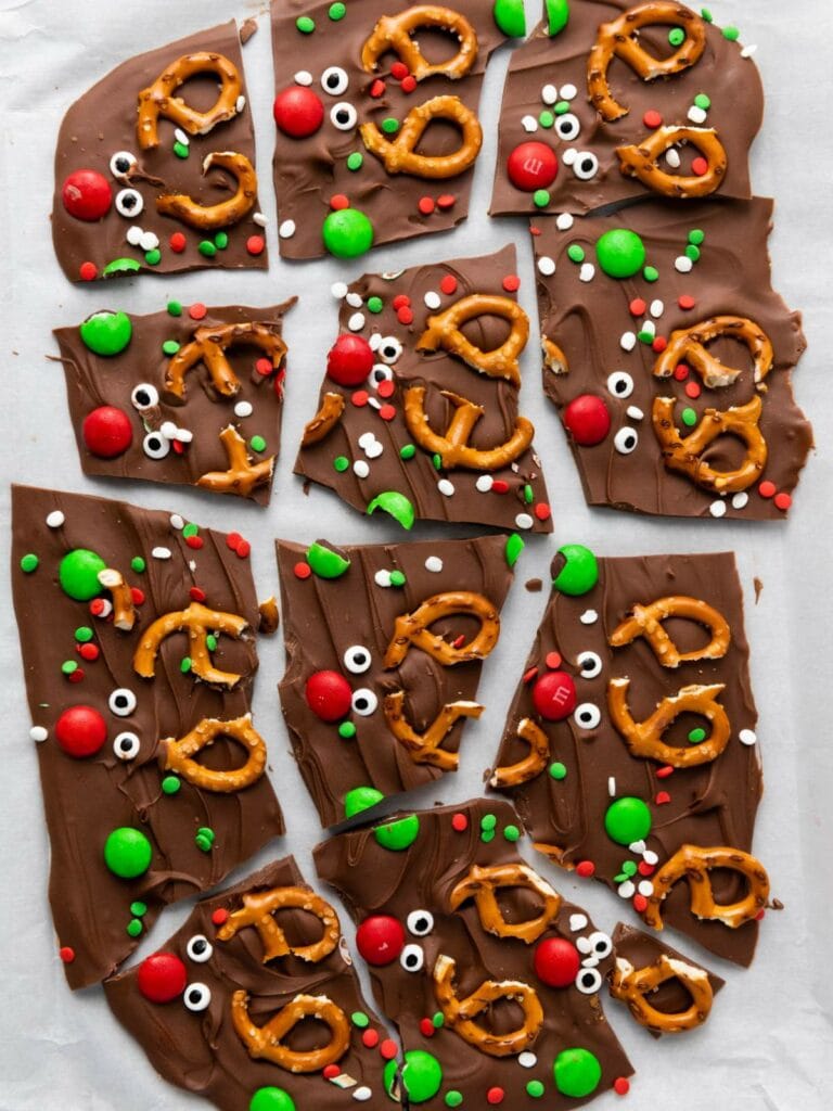 Reindeer chocolate bark pieces arranged on a white surface.