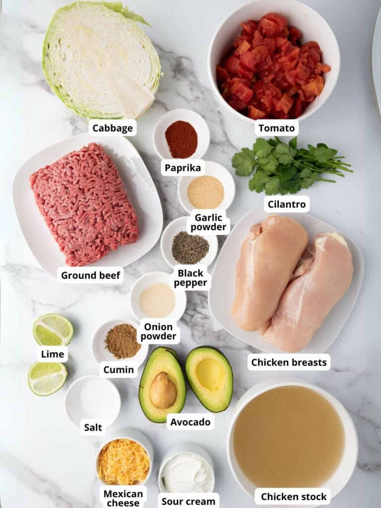 Assorted ingredients for slow cooker taco soup arranged on a marble surface.