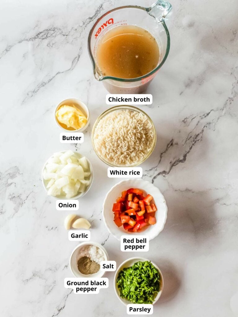 Labeled ingredients for rice pilaf on a marble surface.