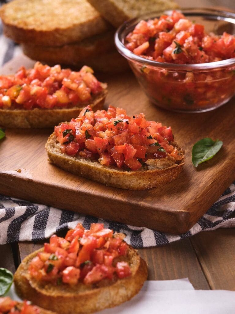 Slices of bread topped with diced tomatoes and herbs.