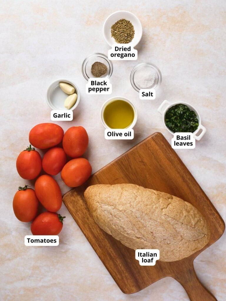 Ingredients for tomato bruschetta on a surface.