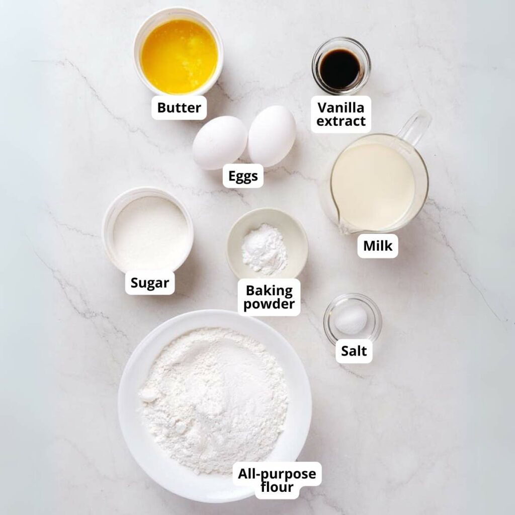 Ingredients for sheet pancakes are laid out on a white surface.