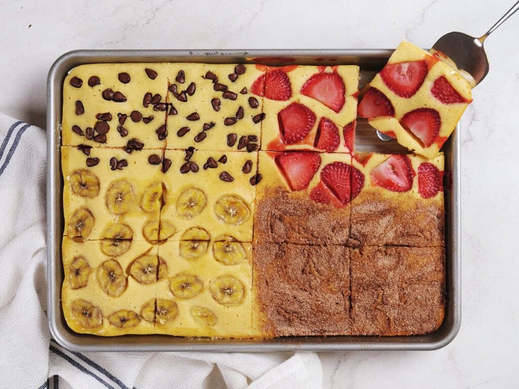 A sheet pan of baked breakfast squares, each quarter topped differently.