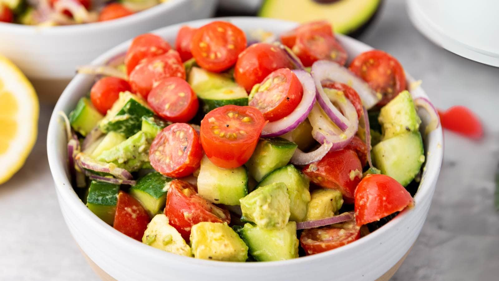 A bowl of avocado salad, tossed with dressing.