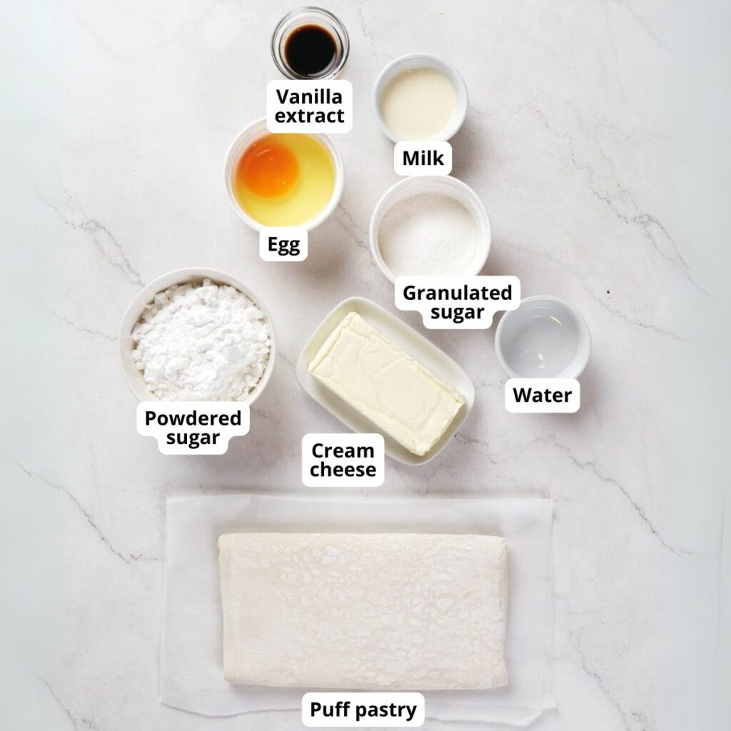 Top-down view of measured ingredients for cream cheese danish on a white surface.