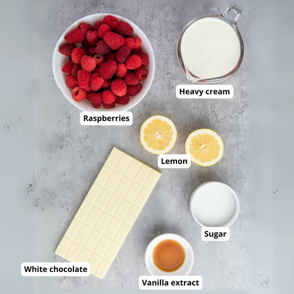 Ingredients for a recipe, including raspberries, heavy cream, lemon, sugar, white chocolate, and vanilla extract, each labeled.